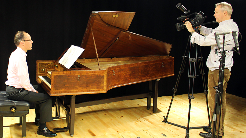 Terence Charlston being filmed playing the harpsichord